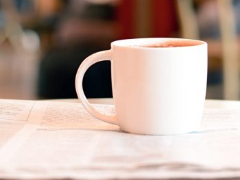 Coffee cup with newspaper on the table